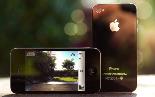 HD desktop wallpaper featuring two Apple Inc. iPhones, one showing a camera interface and the other displaying the back with the Apple logo.