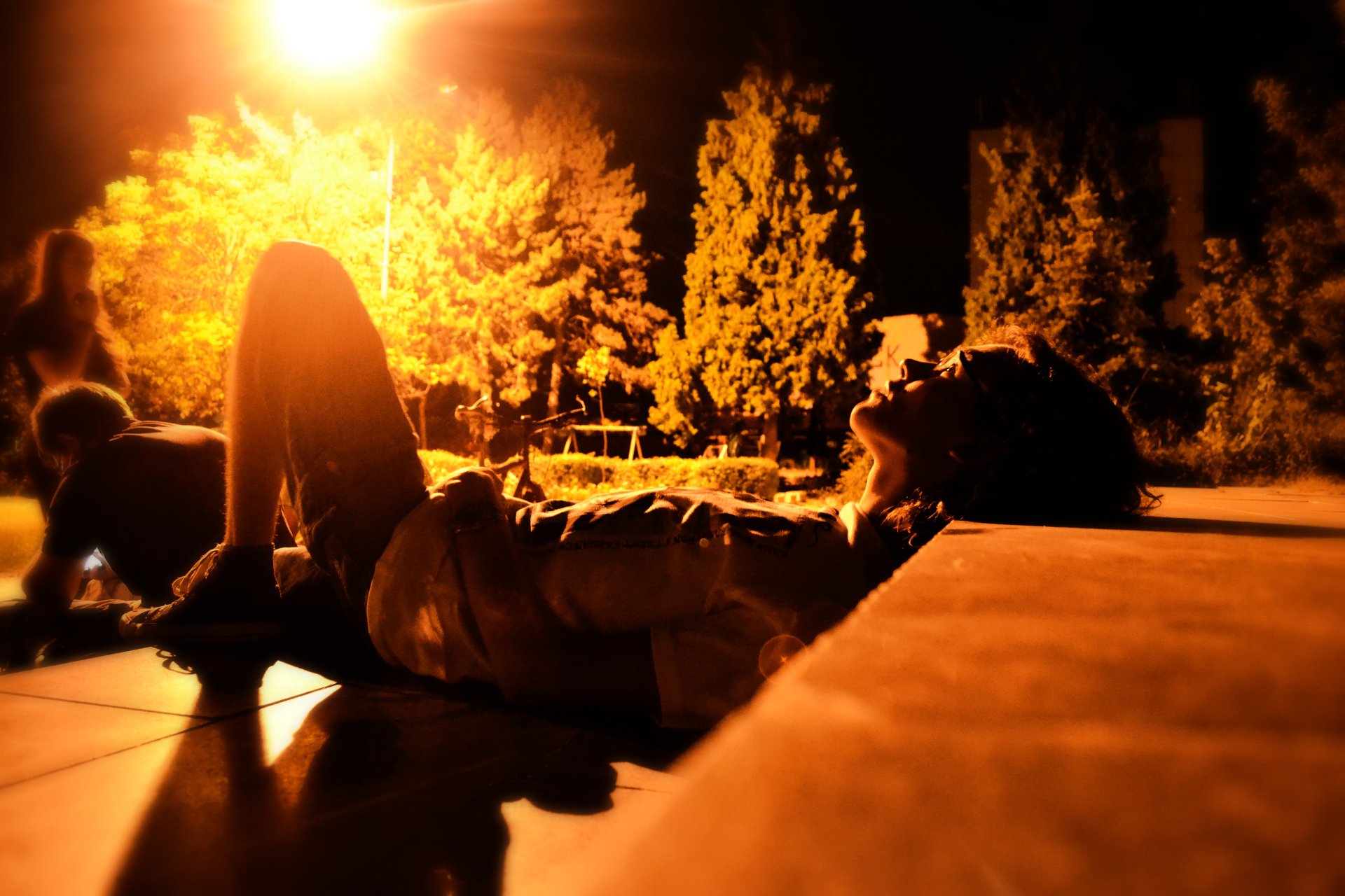 A person lying down outdoors at sunset beneath a glowing star, captured in warm tones for a 4K Ultra HD photography desktop wallpaper.