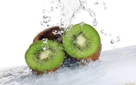 HD desktop wallpaper of fresh kiwi fruit halves with water splashing over them, highlighting vibrant green flesh and natural texture against a clean white background.