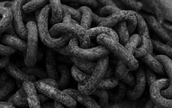 HD desktop wallpaper featuring a close-up of intertwined, weathered metal chains with a monochrome finish.