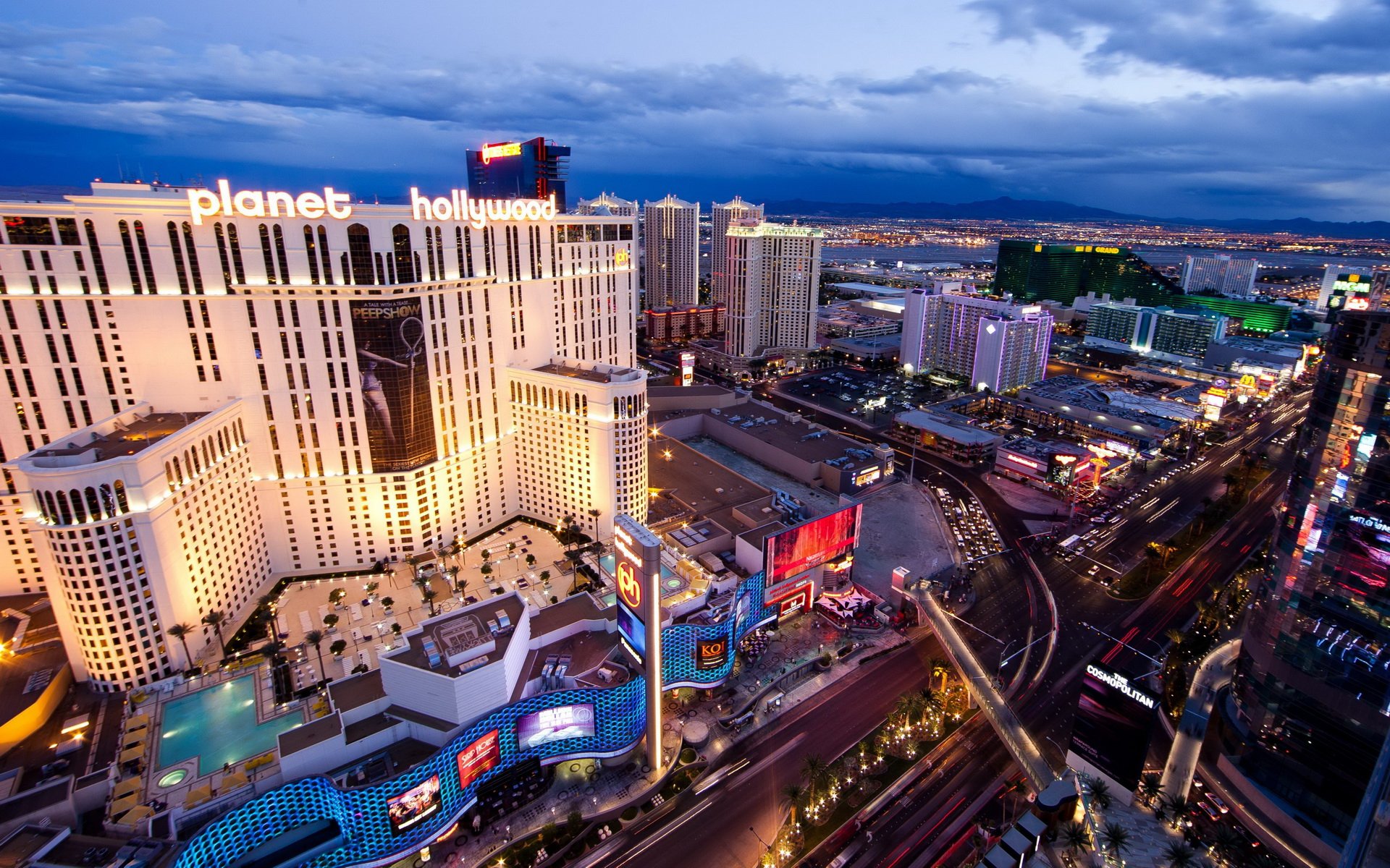 HD desktop wallpaper showcasing the vibrant, illuminated man-made skyline of Las Vegas at dusk with iconic buildings and bustling city lights.