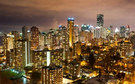 Vibrant night view of Vancouver, Canada, showcasing illuminated skyscrapers and the bustling cityscape, captured in a stunning HD wallpaper.
