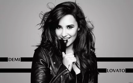 Black and white HD desktop wallpaper featuring Demi Lovato, smiling and holding a microphone, with her name displayed in bold lettering.