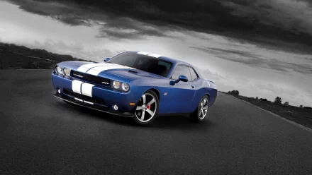 A blue Dodge Challenger SRT8 with white racing stripes on a dark, cloudy road, featured as an HD PC desktop wallpaper and background.