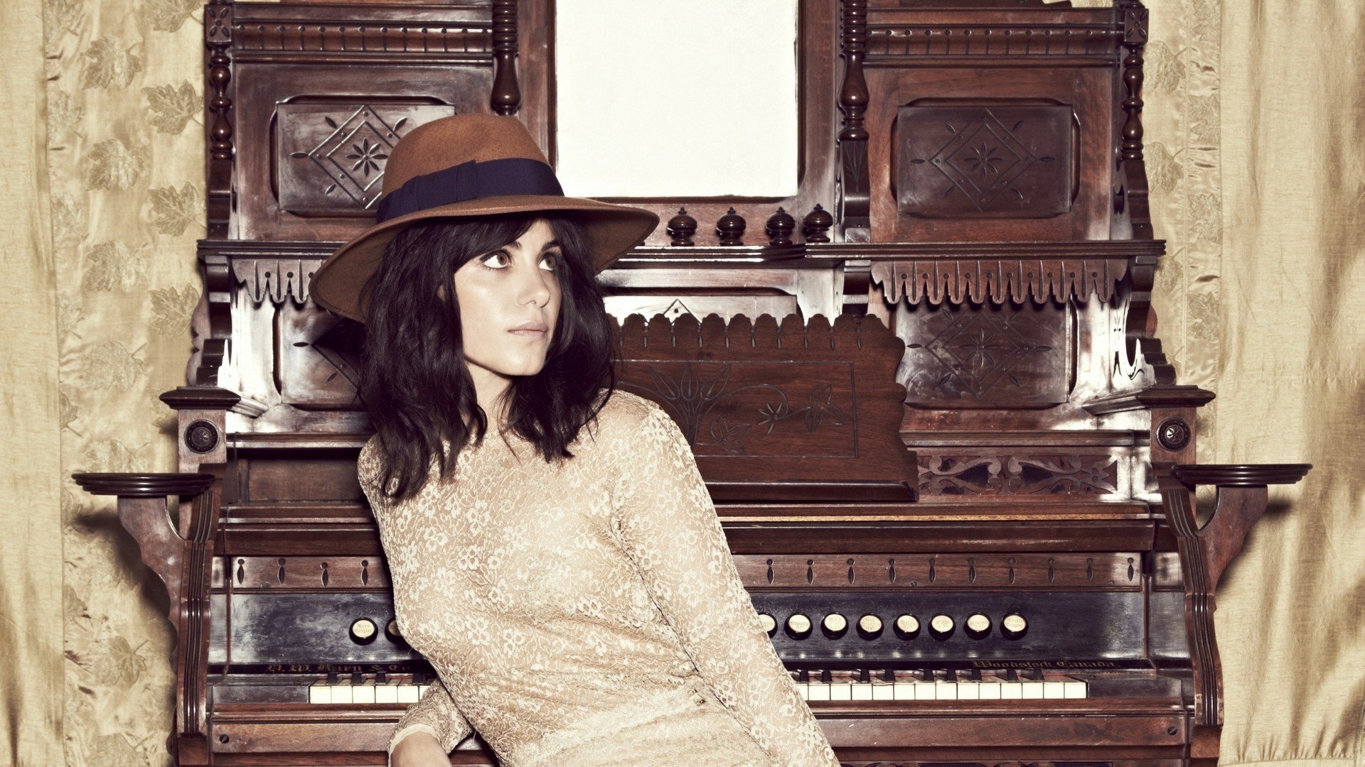 HD desktop wallpaper featuring musician Katie Melua seated in front of an ornate vintage organ, blending classic music elements with a modern artistic vibe.