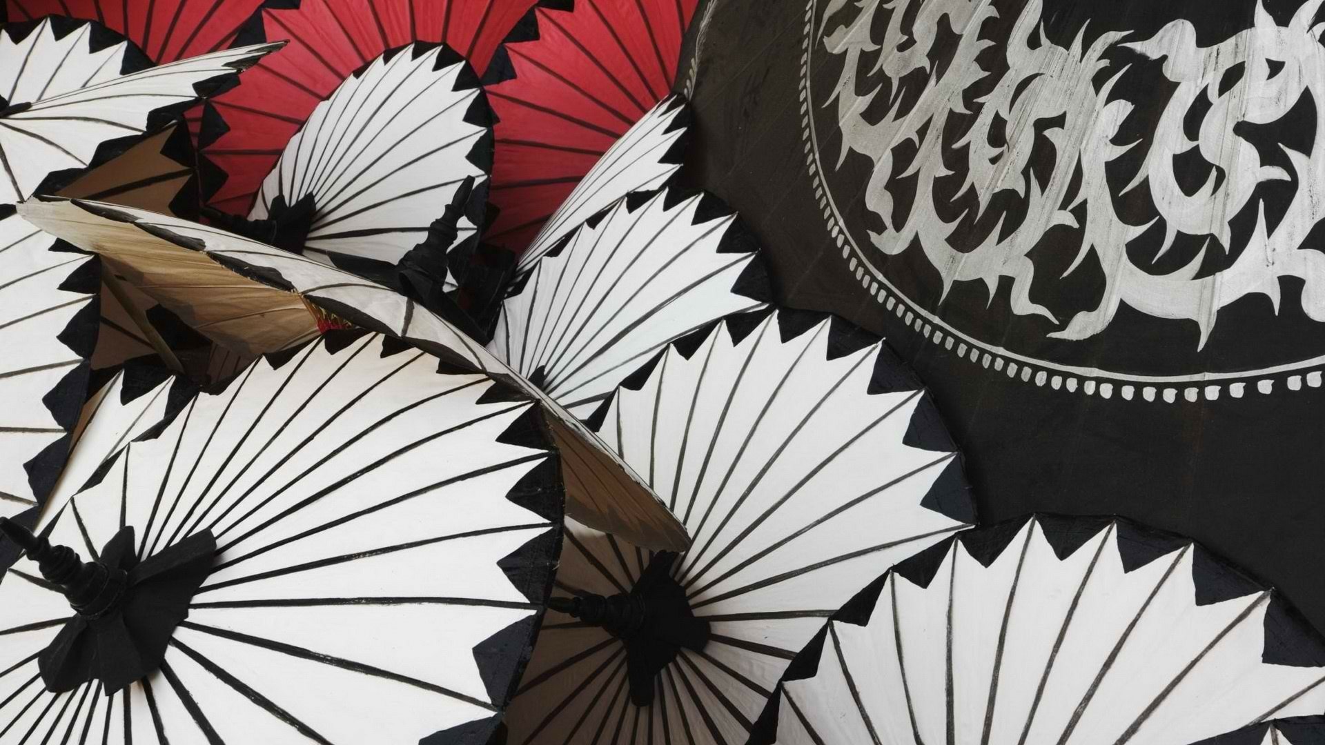 HD photography wallpaper featuring a close-up of traditional Japanese umbrellas with intricate patterns in white, red, and black.
