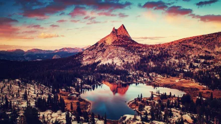 Stunning HD view of Yosemite National Park, featuring a majestic peak reflected in a serene lake surrounded by lush forests and vibrant sunset skies. Perfect nature backdrop for desktops.