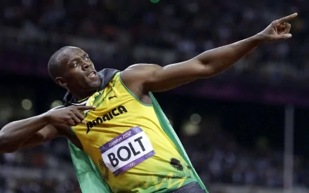 Usain Bolt celebrating after a race in a yellow and green Jamaica jersey, with a crowd in the background. HD desktop wallpaper and background.