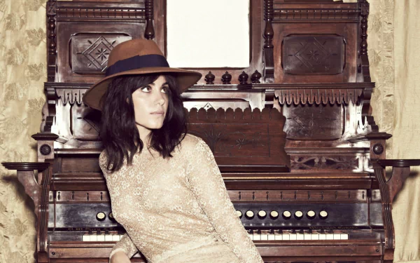 HD desktop wallpaper featuring musician Katie Melua seated in front of an ornate vintage organ, blending classic music elements with a modern artistic vibe.
