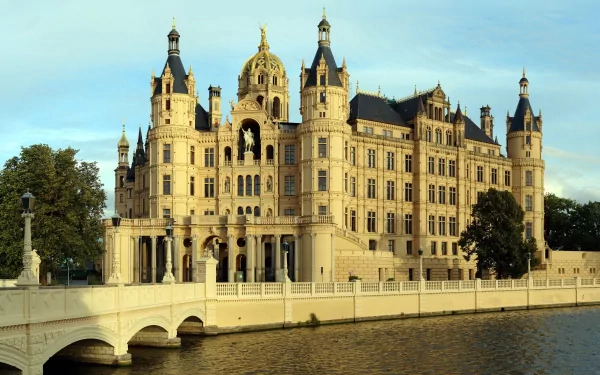 A stunning view of Schwerin Palace, showcasing its intricate architecture reflected in the surrounding water, designed as a 4K Ultra HD PC desktop wallpaper and background.