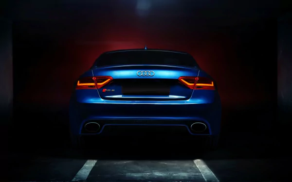 A striking HD wallpaper featuring an Audi RS6 showcased from the rear, illuminated by dramatic lighting, with an Audi RS5 subtly suggested in the background.