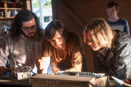 HD wallpaper of three individuals intensely focusing on a task, reminiscent of a job-related group activity, suitable as a desktop background.