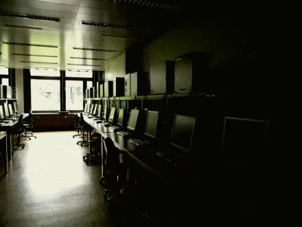 Dim IBM computer lab with rows of monitors and chairs, high-contrast 4K Ultra HD PC desktop wallpaper background showcasing technology.