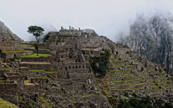HD desktop wallpaper showcasing the man-made ancient stone terraces and structures of Machu Picchu set against misty mountain peaks.