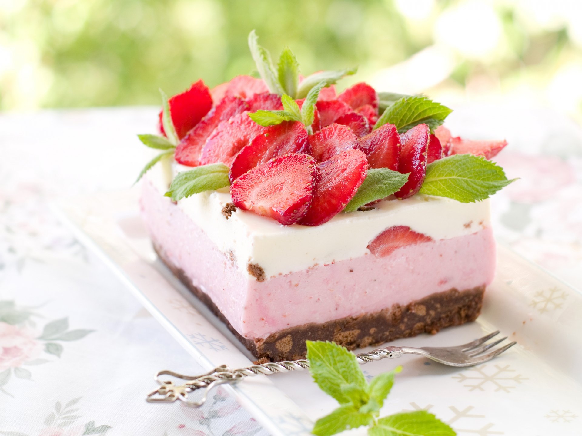 HD desktop wallpaper of a strawberry dessert pastry with layers of cake, creamy filling, and fresh strawberry slices garnished with mint leaves.