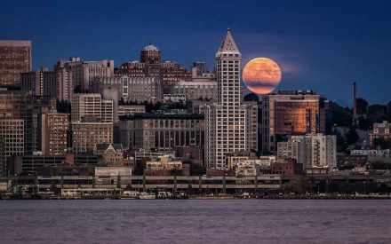 HD PC desktop wallpaper featuring the man-made Seattle skyline at dusk with a large, glowing full moon rising behind the buildings.