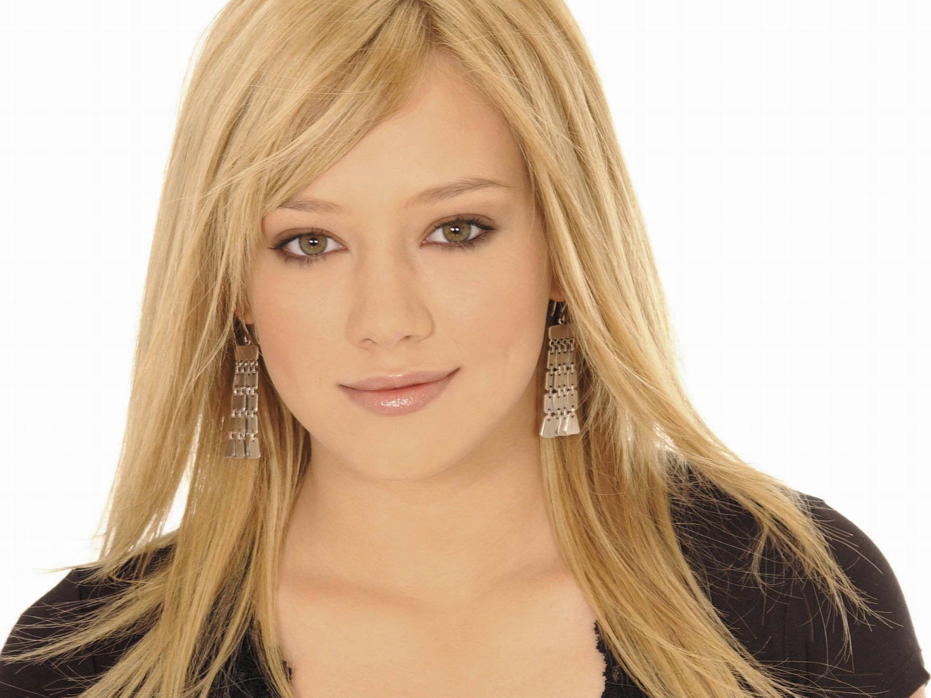 HD PC desktop wallpaper featuring a close-up portrait of celebrity Hilary Duff with blonde hair and a neutral expression against a white background.