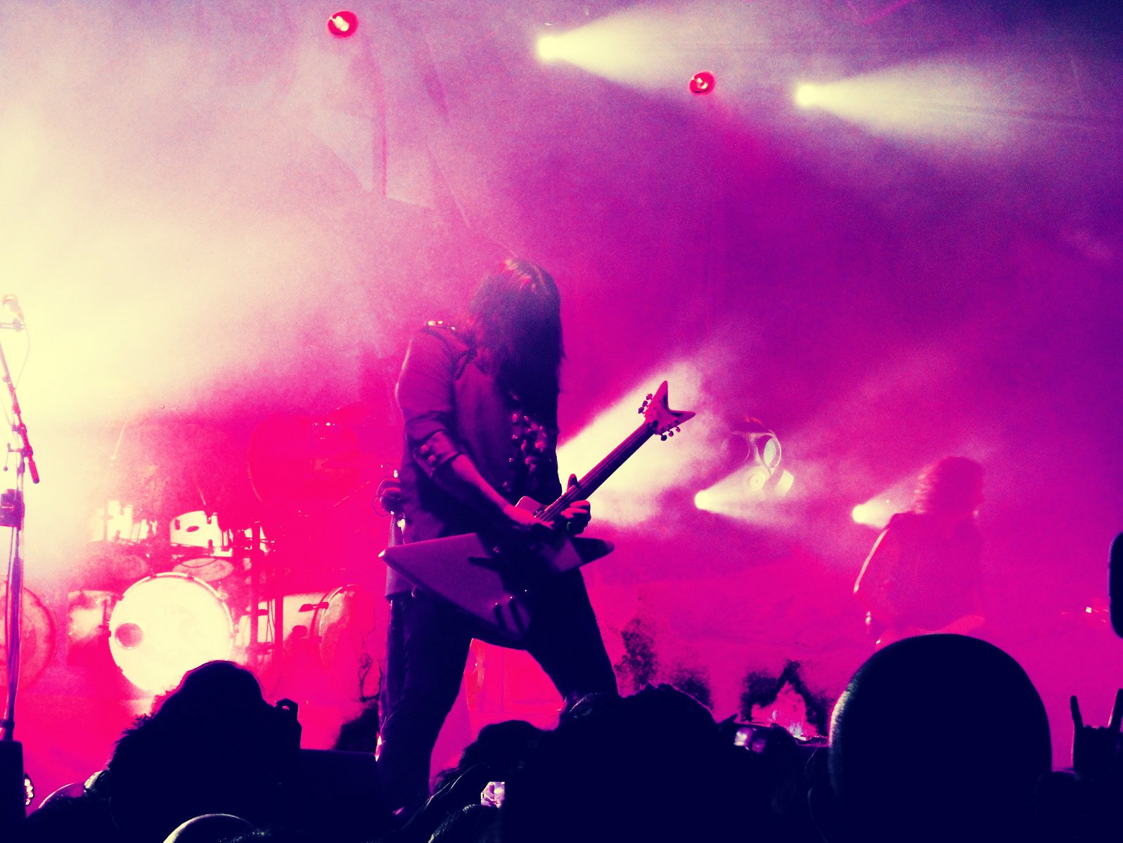 HD PC desktop wallpaper featuring a musician playing an electric guitar on stage amid vibrant pink and purple lighting with a lively concert atmosphere.