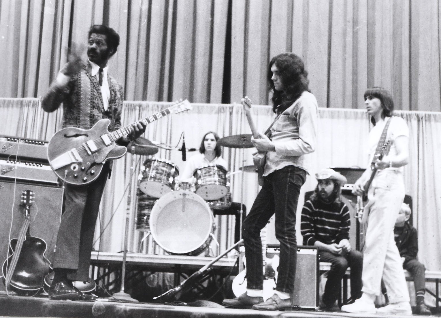 Black-and-white HD desktop wallpaper showing Chuck Berry playing guitar on stage with a band, capturing a classic moment in music history.