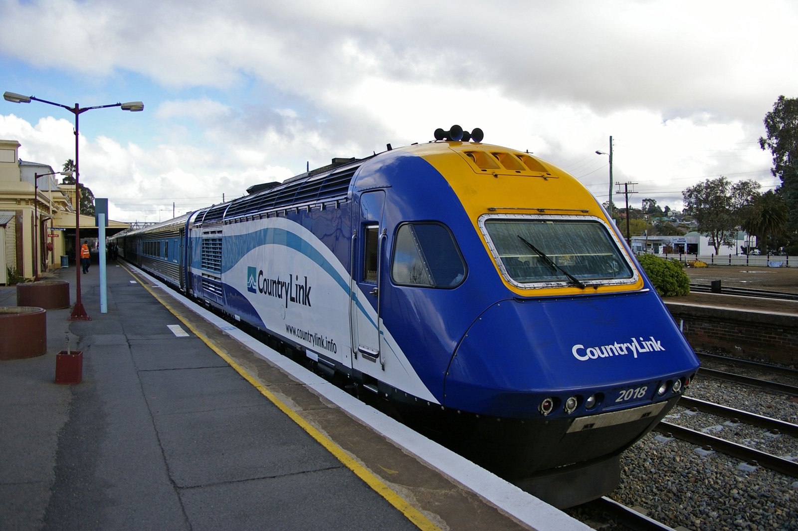 HD desktop wallpaper featuring a New South Wales XPT train at a station platform, showcasing the sleek blue and yellow design of this iconic vehicle.