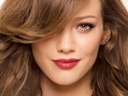 HD PC desktop wallpaper featuring a close-up portrait of celebrity Hilary Duff with soft waves and vibrant makeup.