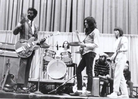Black-and-white HD desktop wallpaper showing Chuck Berry playing guitar on stage with a band, capturing a classic moment in music history.