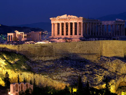 Man-made Acropolis of Athens at night: the illuminated Parthenon atop the rocky hill with warm lights and cityscape — HD PC desktop wallpaper and background.