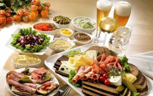 A vibrant spread of assorted meats, cheeses, salads, pickles, and condiments, accompanied by drinks. This HD PC desktop wallpaper showcases a delightful meal.