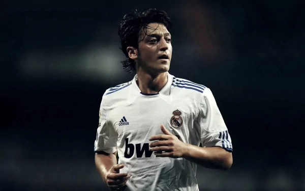 HD PC desktop wallpaper featuring Mesut Özil in a white Real Madrid football jersey during a match, highlighting his focus and athleticism in sports.