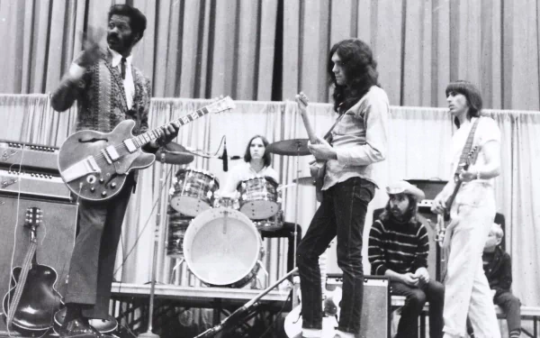 Black-and-white HD desktop wallpaper showing Chuck Berry playing guitar on stage with a band, capturing a classic moment in music history.