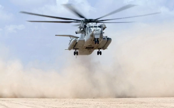 Military Sikorsky MH-53 helicopter hovering above a dusty desert landscape, captured in high definition as a dynamic PC desktop wallpaper background.