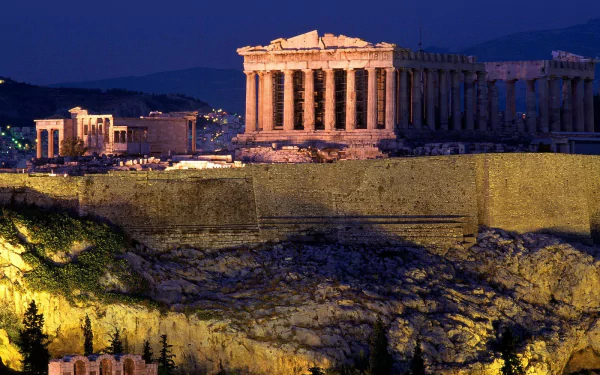 Man-made Acropolis of Athens at night: the illuminated Parthenon atop the rocky hill with warm lights and cityscape — HD PC desktop wallpaper and background.