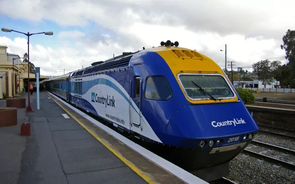 HD desktop wallpaper featuring a New South Wales XPT train at a station platform, showcasing the sleek blue and yellow design of this iconic vehicle.