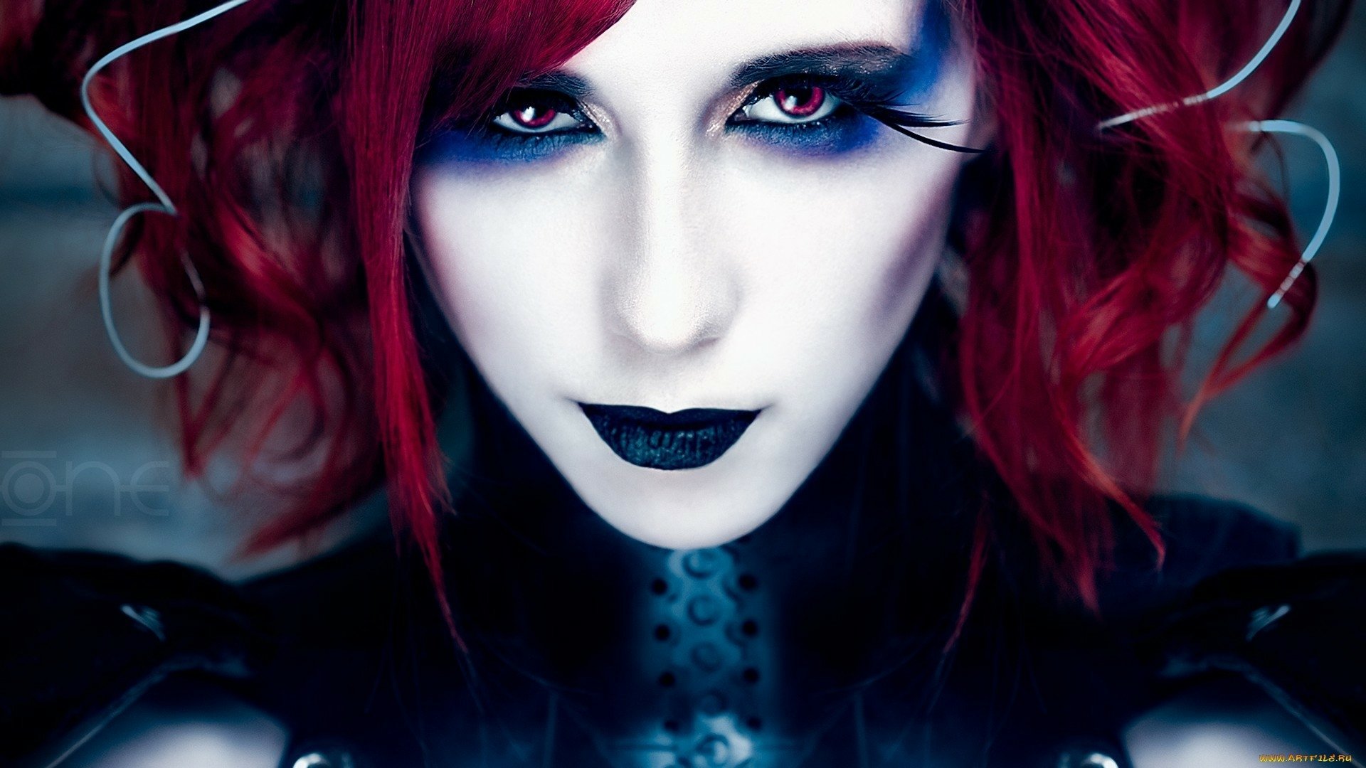 A striking HD wallpaper featuring model Stephanie van Rijn with bold red hair and dramatic makeup, presenting an intense and captivating expression.