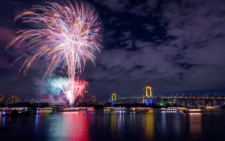 Photography — HD PC desktop wallpaper and background: colorful fireworks burst over a lit bridge at night, vivid reflections shimmering across the river.