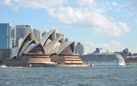 A vibrant view of Sydney's iconic Opera House and a cruise ship, reflecting the lively carnival spirit of Australia's urban landscape and showcasing man-made beauty against a scenic backdrop.