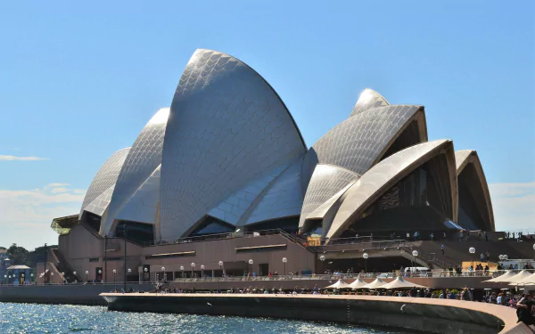 A stunning view of the iconic Sydney Opera House at Circular Quay, Australia, showcasing its unique architectural design against a clear blue sky.