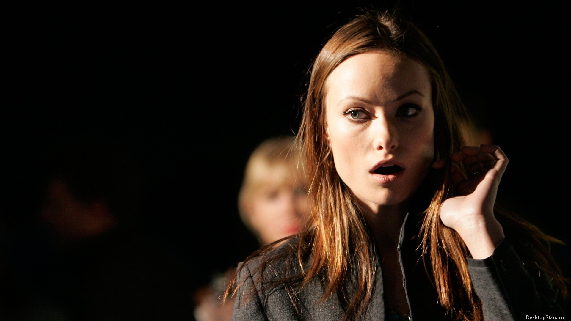HD PC desktop wallpaper featuring celebrity Olivia Wilde with a dramatic expression against a dark background.