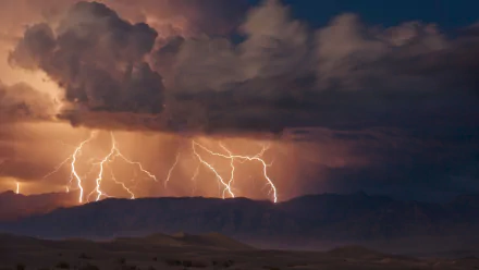 HD PC desktop wallpaper featuring a dramatic lightning storm illuminating dark clouds over a mountainous landscape, captured in stunning photographic detail.