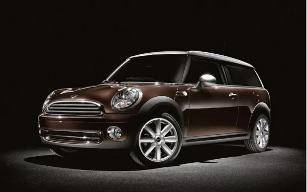 HD desktop wallpaper featuring a sleek brown Mini Cooper vehicle against a dark background, highlighting its compact and stylish design.