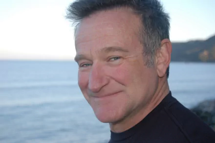 HD desktop wallpaper of Robin Williams smiling with a serene seascape in the background.
