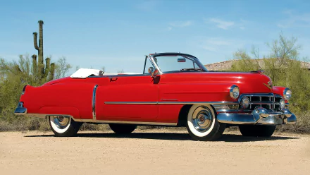 A red Cadillac Sixty-Two convertible parked on a desert road with cacti in the background, shown as an HD PC desktop wallpaper and background.