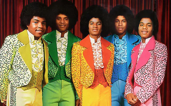 HD desktop wallpaper featuring The Jackson 5 dressed in vibrant, colorful suits standing against a red curtain, celebrating iconic music history.