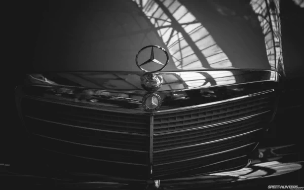 Close-up HD PC desktop wallpaper of a Mercedes-Benz vehicle grille with the iconic emblem reflecting light and shadows.