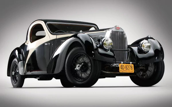 A stunning HD wallpaper featuring a classic Bugatti vehicle in a sleek black and cream design, showcasing its elegant contours and vintage charm.