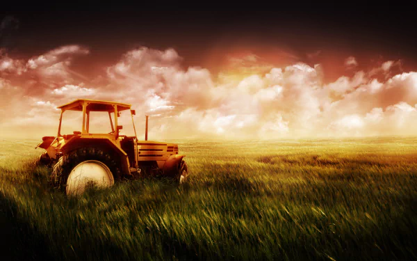A vibrant HD desktop wallpaper of a tractor in a lush green field under a dramatic sky, capturing the essence of rural life and agricultural beauty.