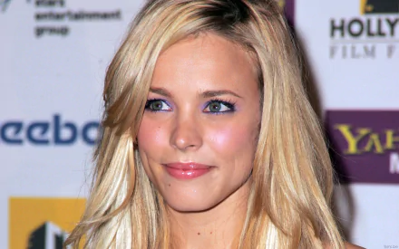 Rachel McAdams smiles warmly in this HD desktop wallpaper, showcasing her vibrant features and elegant style at a film event backdrop.