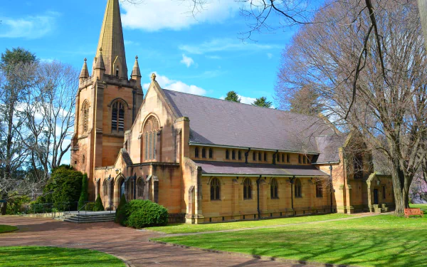 A picturesque church in Lithgow, Australia, showcases stunning architecture surrounded by greenery and trees, capturing a serene blend of nature and religious heritage.