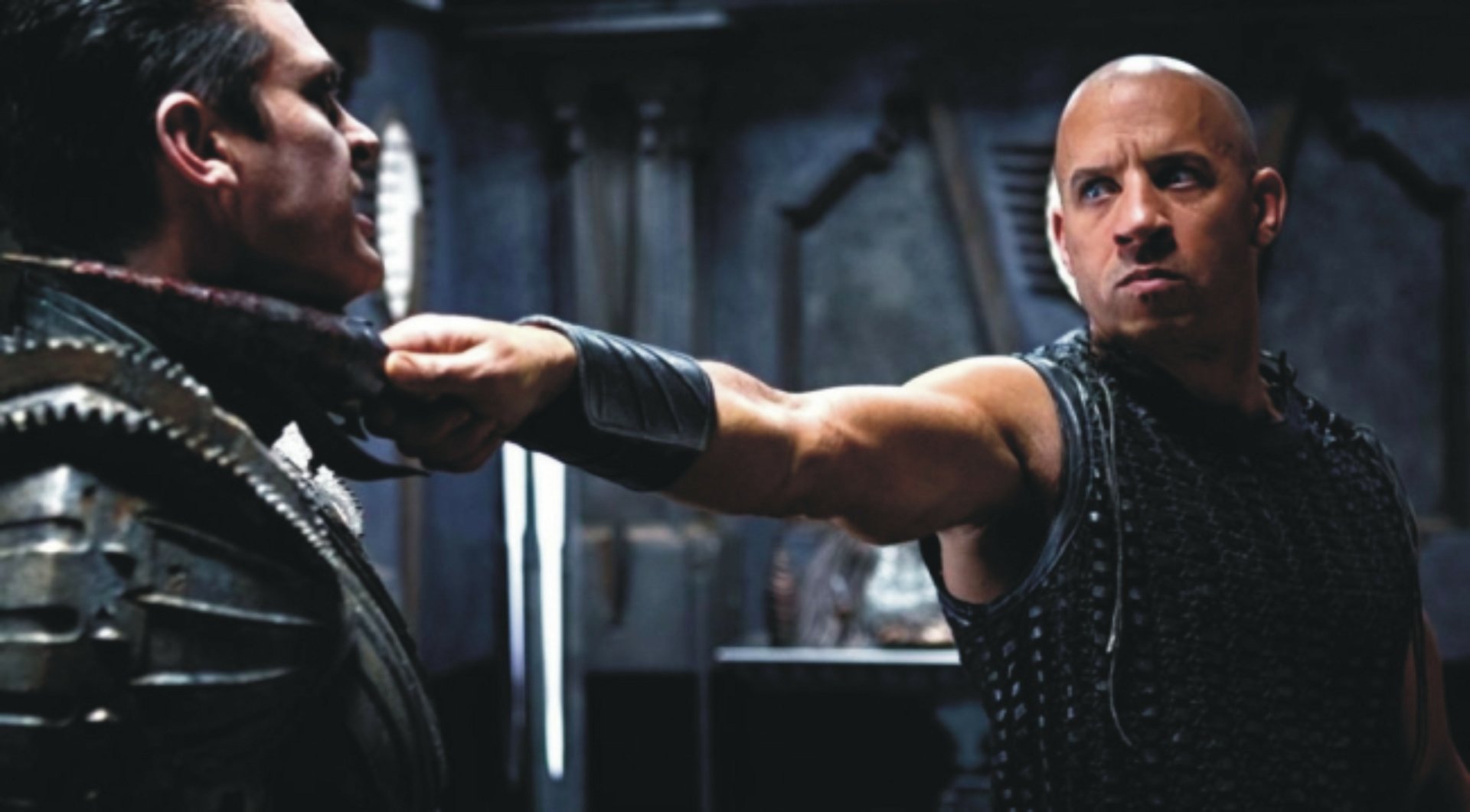 4K Ultra HD PC desktop wallpaper from the movie The Chronicles of Riddick: a bald, armored man grips another's collar in a tense, dimly lit sci‑fi confrontation.