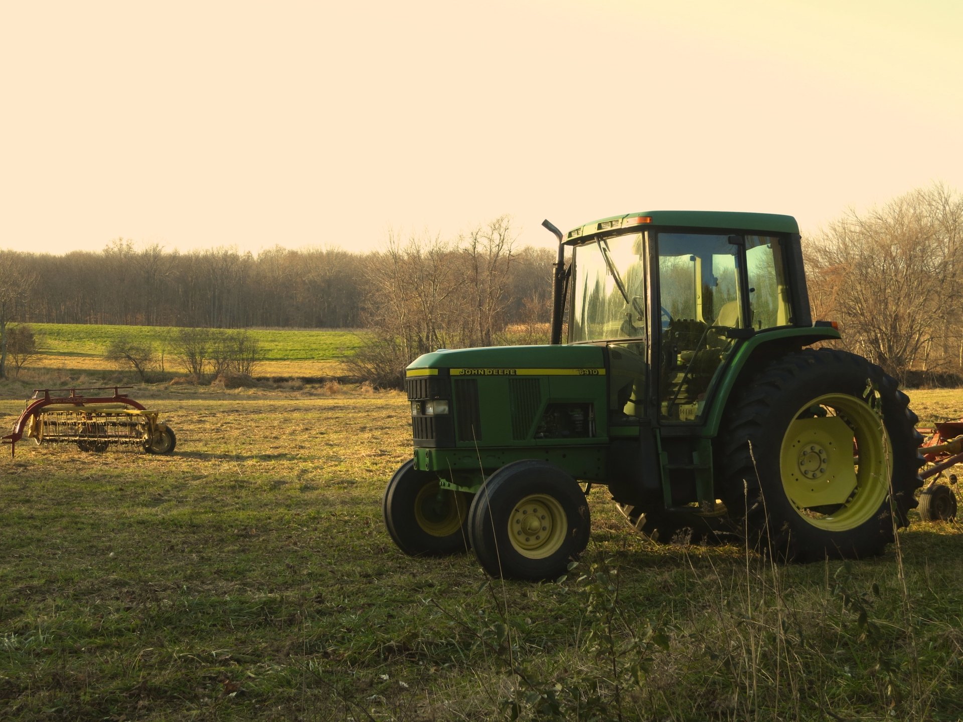 4K Ultra HD PC desktop wallpaper and background: green John Deere tractor parked in a sunlit rural field with harvest equipment in the distance.